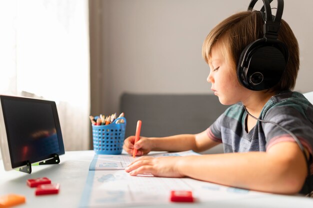 Child wearing headphones attending virtual school