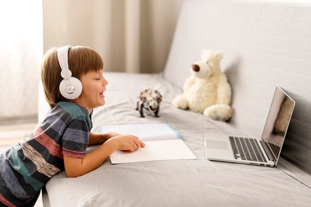 Foto gratuita bambino che indossa le cuffie interazioni scolastiche online