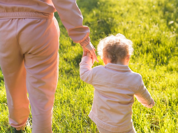 Child wearing pink clothes and mom from behind