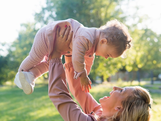 Child wearing pink clothes and mom holding her