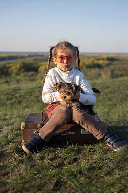 Child wearing sunglasses playing with her dog