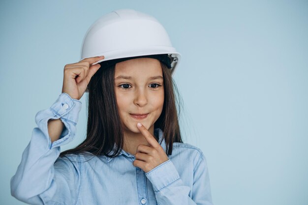 Child wearing white safety hat on blue background