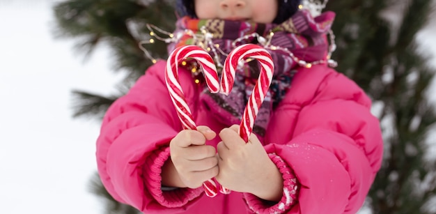 Child with a big candy canes. Christmas concept.
