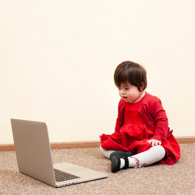 Child with down syndrome looking at laptop