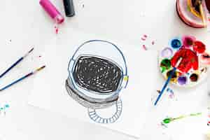 Free photo child with a drawing of astronaut helmet