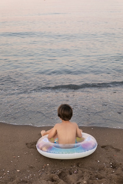 Child with floater by the seaside