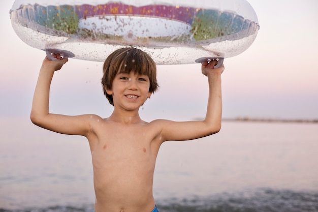 Foto gratuita bambino con galleggiante in riva al mare