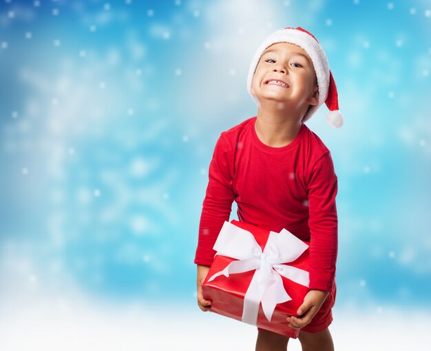 Ребенок с подарком со снегом фоне