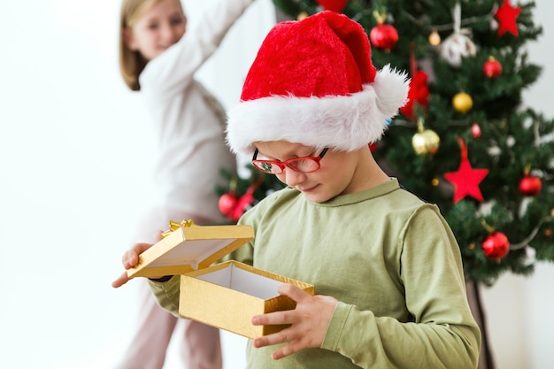 Child with a golden gift and a santa hat