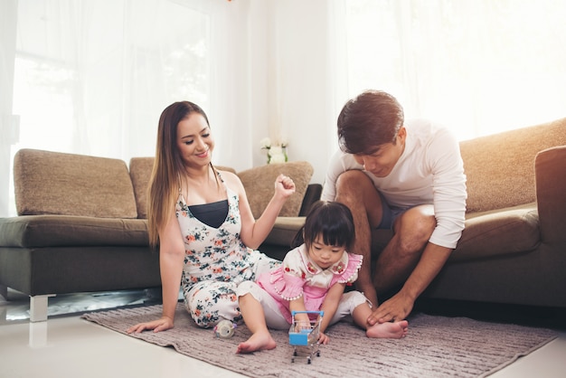 Free photo child with her parent playing on floor in living room