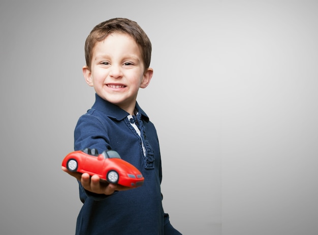 Foto gratuita bambino con una macchina rossa