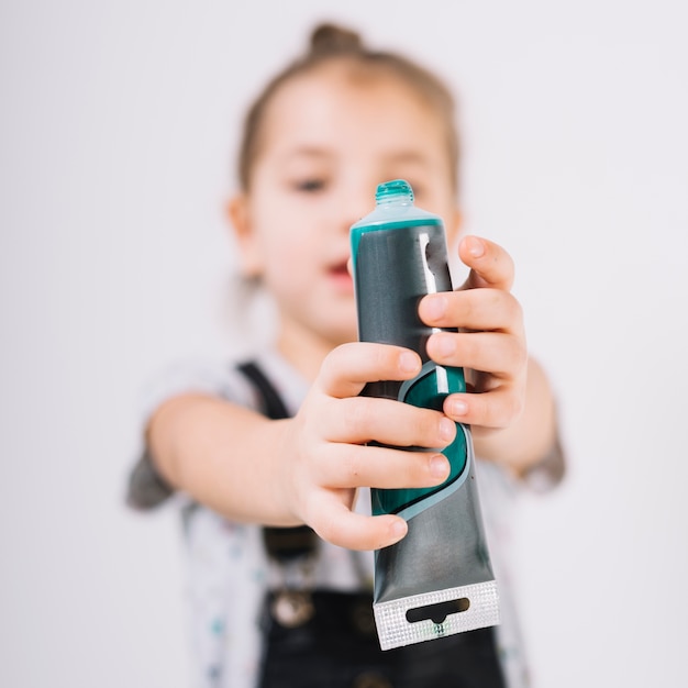 Free photo child with tube of colors in hands