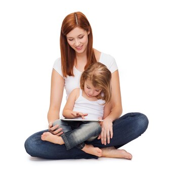 Childhood, parenting and technology concept - happy mother with adorable little girl and tablet pc computer