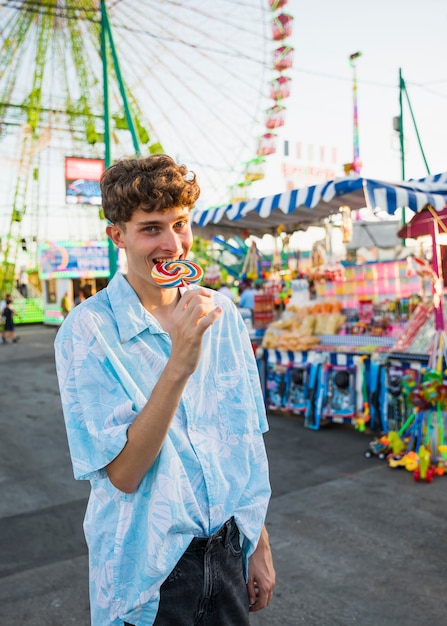 Childish man enjoying lollipop at funfair