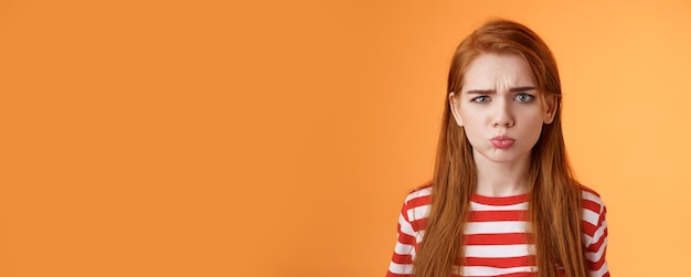 Free photo childish offended cute redhead girl pouting sulking upset frowning complain unfair situation whining