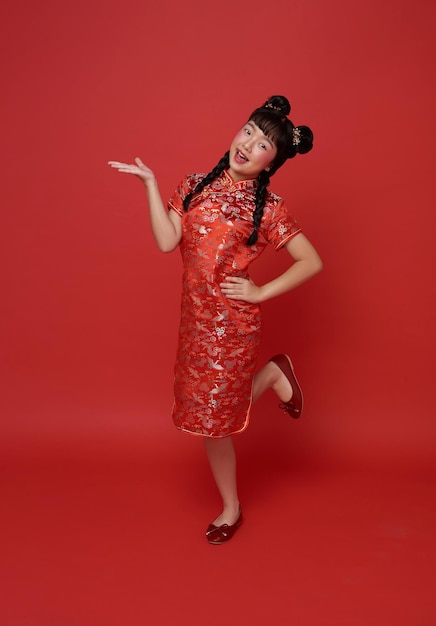 빨간색을 입은 아시아 소녀, 전통적인 시마 파오, 중국 신년 축하 제스처