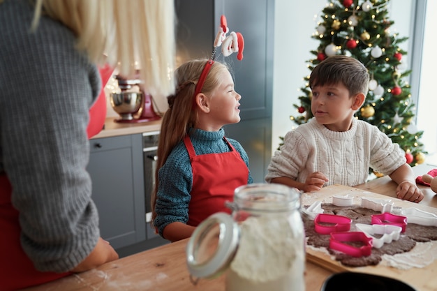 クリスマスの時期にジンジャーブレッドのクッキーを焼く子供たち