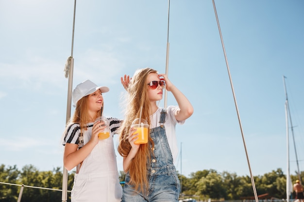 The children on board of sea yacht drinking orange juice