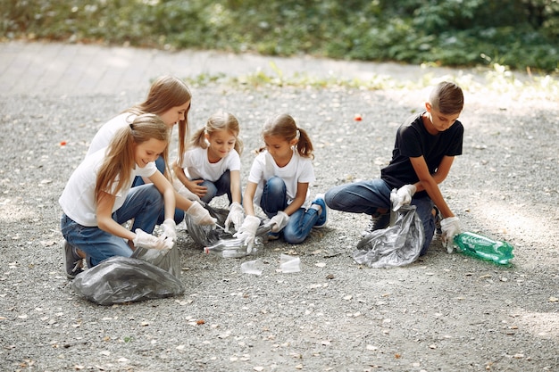 Children collects garbage in garbage bags in park