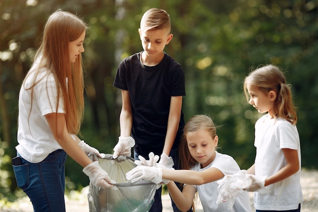 I bambini raccolgono immondizia nei sacchetti di immondizia nel parco