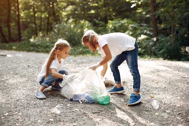 Children collects garbage in garbage bags in park