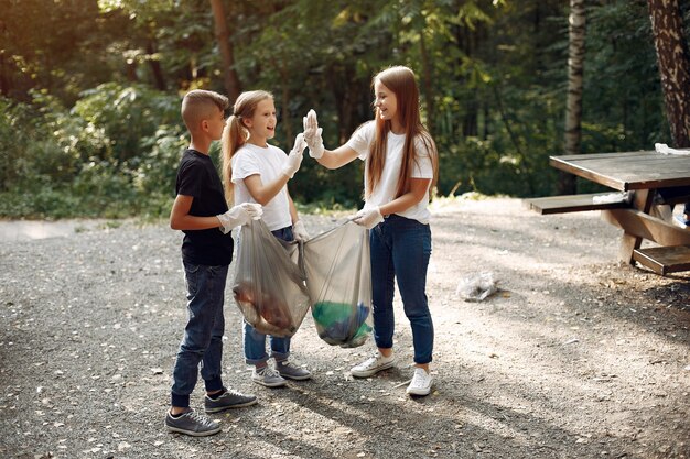 Children collects garbage in garbage bags in park
