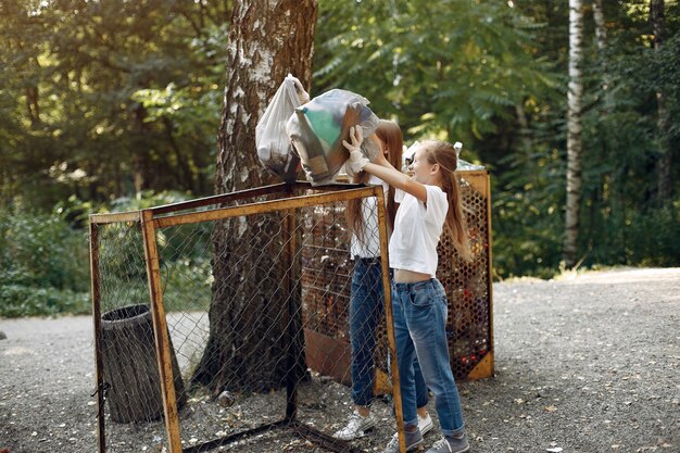 Children collects garbage in garbage bags in park