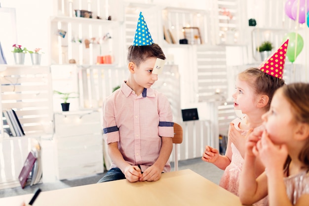 Children in colored caps playing paper game