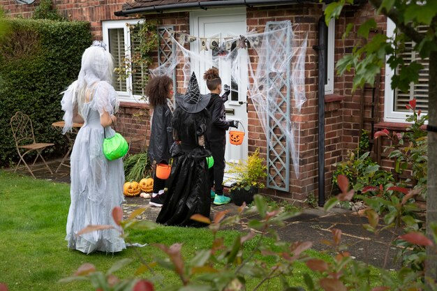 Children in costumes trick or treating at someone's house