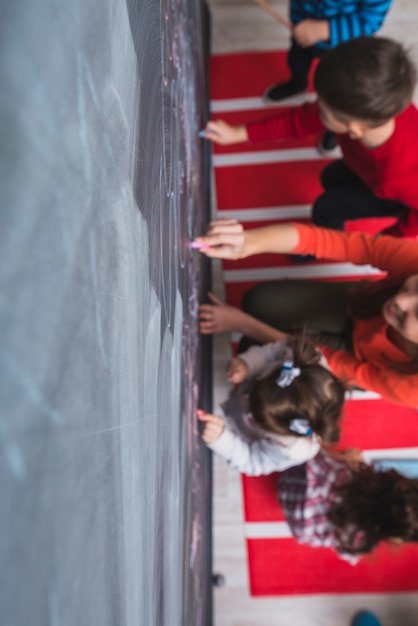 Children drawing on blackboard