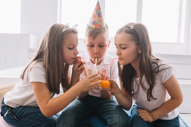 Free photo children drinking from glasses on birthday party