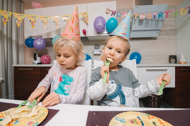 무료 사진 생일 케이크를 먹는 아이들