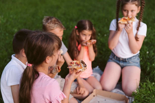 Дети вместе едят пиццу