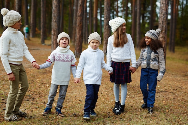 Foto gratuita bambini che godono a piedi nella foresta d'autunno