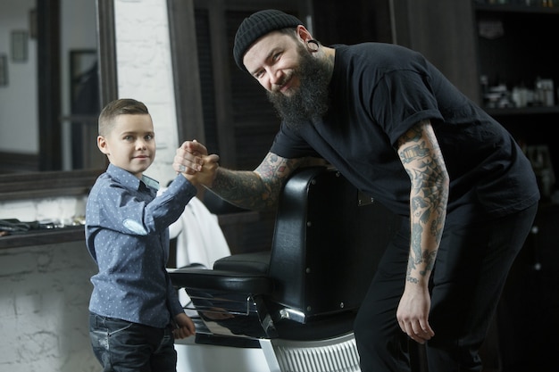 Children hairdresser and little boy against dark