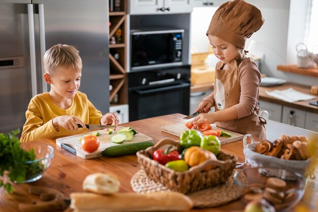 Дети весело готовят на кухне дома