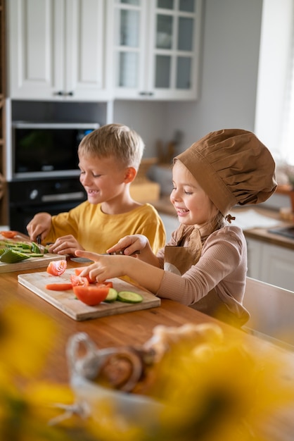 Foto gratuita i bambini si divertono a cucinare in cucina a casa