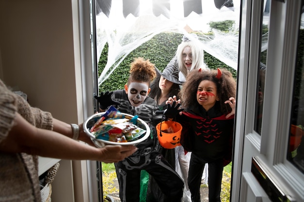 Дети в костюмах трюк или угощение на хэллоуин