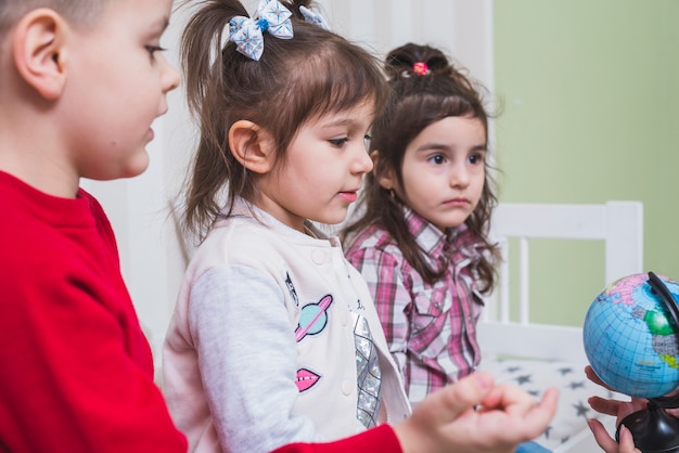 Children learning globe in bedroom