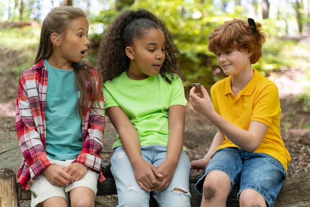 Children looking together at a snail