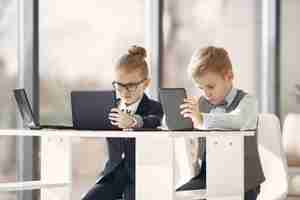 Foto gratuita bambini in ufficio con un computer portatile