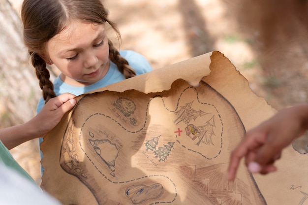 Foto gratuita bambini che partecipano a una caccia al tesoro in una foresta