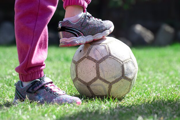아이들은 잔디에서 축구를하고, 공 위에 발을 유지합니다. 팀 게임의 개념.
