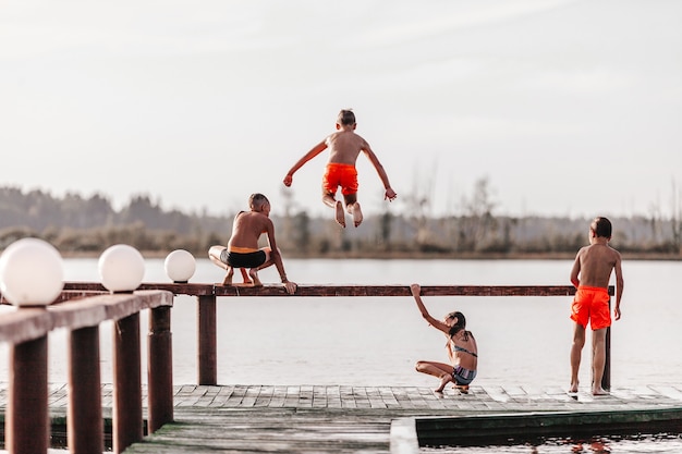 Children playing and  jumping into the water in swimsuits