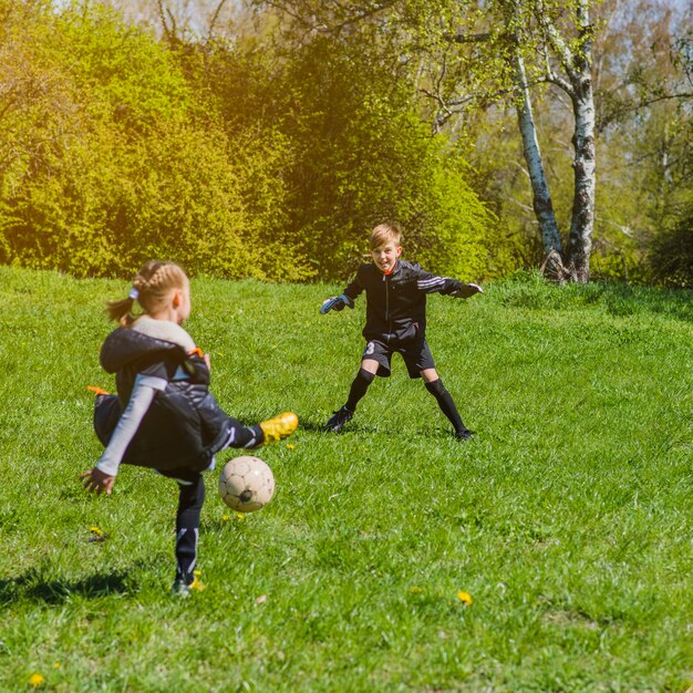 晴れた日にサッカーをしている子供たち