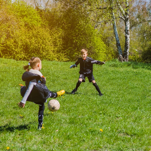 晴れた日にサッカーをしている子供たち