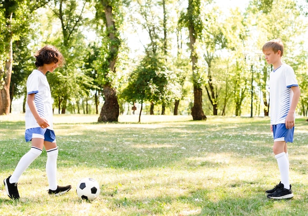外で一緒にサッカーを遊んでいる子供たち