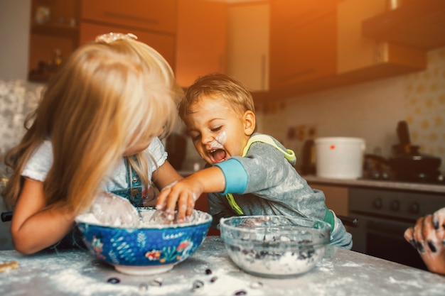 Bambini che giocano con una ciotola di farina