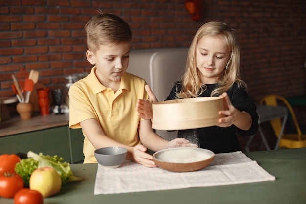 Children playing with a flour in a kitchen