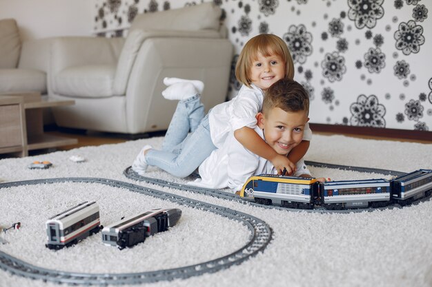 Children playing with lego and toy train in a playing room